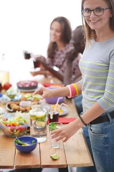 Top view of group of people having dinner together while sitting at wooden table. Food on the table. People eat fast food