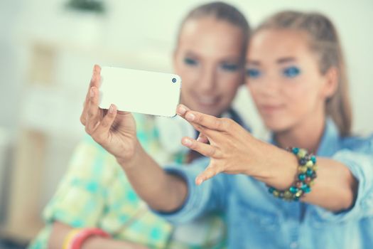 Two girls taking pictures on the phone