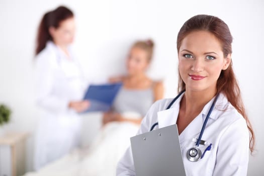 Smiling female doctor with a folder in uniform standing