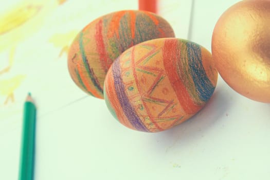 Painted eggs and pencil on white background.