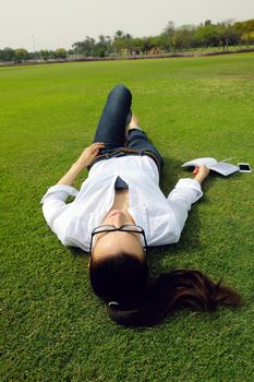 Young student woman reading a book and study in the park