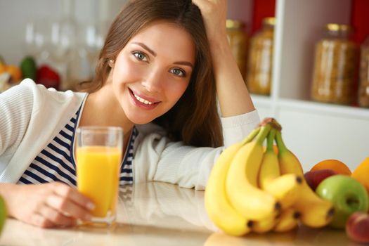 Young woman sitting near desk in the kitchen.