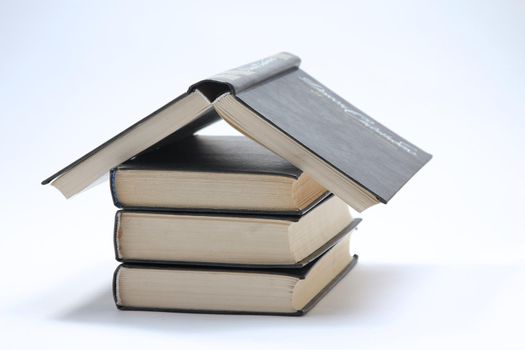 House made with books piled on white background.