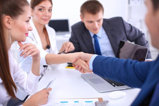 Business people shaking hands, finishing up a meeting, in office.