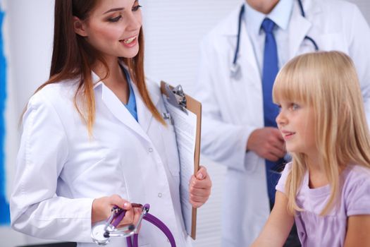 Female doctor examining child with stethoscope at surgery.