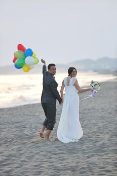 happy just married young couple celebrating and have fun at beautiful beach sunset