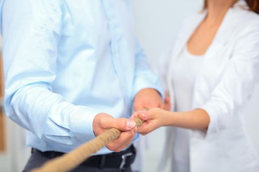 Concept image of business team using a rope as an element the teamwork on foreground.