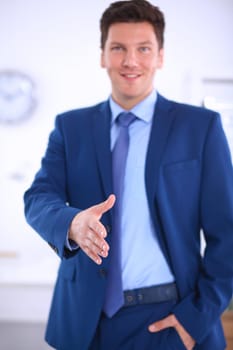 Business and office concept - businessman with open hand ready for handshake