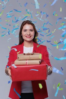 Beautiful happy woman with gift box at celebration party with confetti . Birthday or New Year eve celebrating concept.