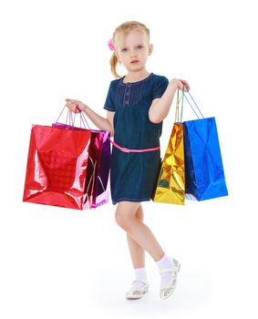 Little girl holding her in front of shopping bags, isolated on white background.