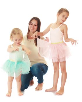 Beautiful young mother hugging 2 of their favorite daughters . Girls dressed in costumes of the dancers.Isolated on white.
