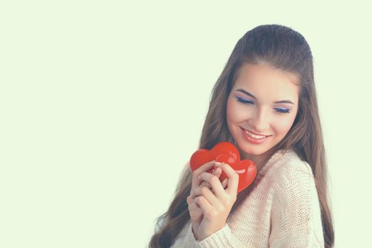 Beautiful woman hold red hear, isolated on gray background.