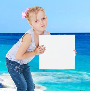 Girl in gray shirt holding a white banner on the background of the sea.