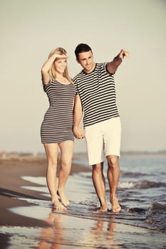 happy young couple have romantic time on beach at sunset