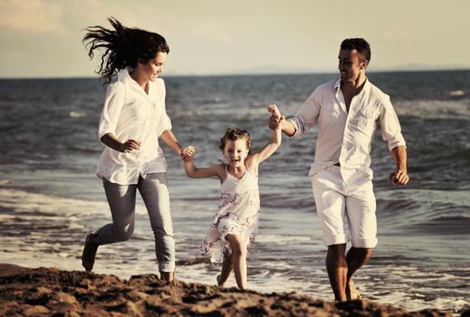 happy young family in white clothing have fun at vacations on beautiful beach