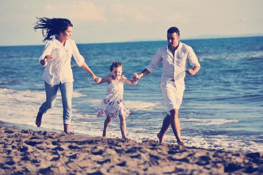 happy young family in white clothing have fun at vacations on beautiful beach