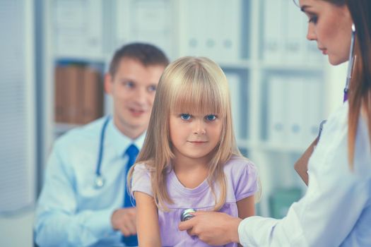 Female doctor examining child with stethoscope at surgery.