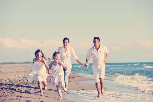 happy young family in white clothing have fun at vacations on beautiful beach 