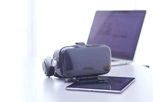 Virtual reality goggles on desk with laptop. business. 3d technology.