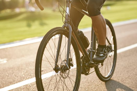 Close up shot of male cyclist legs, man cycling outdoors on a summer day. Active lifestyle concept