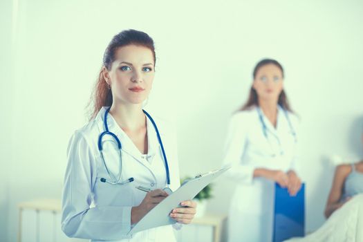 Woman doctor with folder standing at hospital.