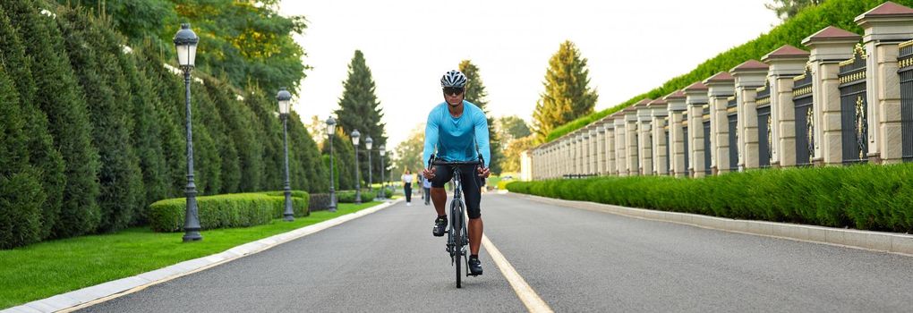 Cropped shot of a man riding mountain bike in park during sunset, cycling outdoors on a summer day. Active lifestyle concept