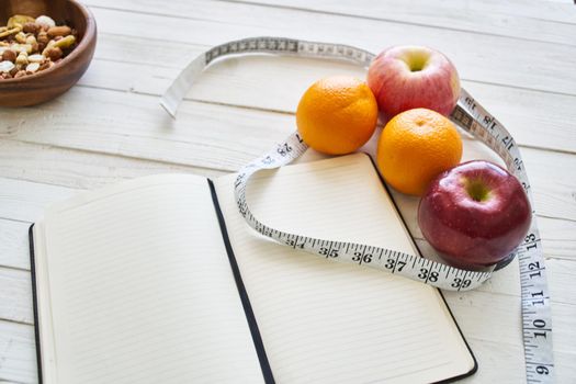 notepad on table measuring tape fruit breakfast nutritional fitness. High quality photo