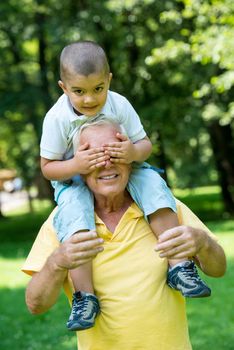 happy grandfather and child have fun and play in park on beautiful  sunny day