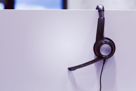 Headphones hanging on cubicle partition in empty call center office