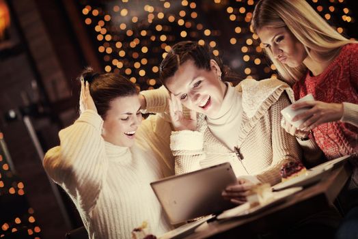 happy girls group  looking at a pc tablet in a home interior and have fun