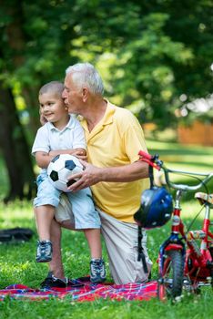 happy grandfather and child have fun and play in park on beautiful  sunny day