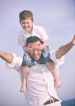 happy young  father and son have fun and enjoy time on beach at sunset and representing healthy family and support concept