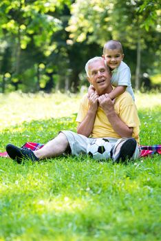 grandfather and child using tablet computer in park