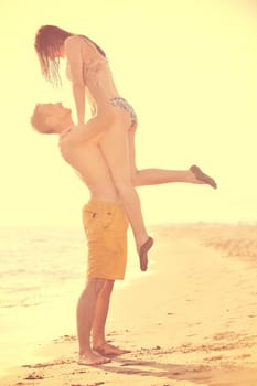 happy young couple have romantic time on beach at sunset