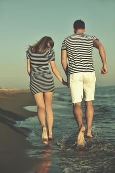 happy young couple have romantic time on beach at sunset