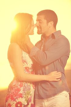 happy young couple have romantic time on beach at sunset