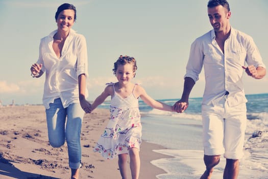 happy young family in white clothing have fun at vacations on beautiful beach 