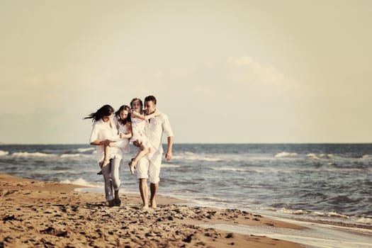 happy young family in white clothing have fun at vacations on beautiful beach 