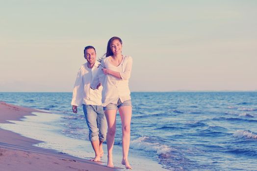 happy young romantic couple in love have fun on beautiful beach at beautiful summer day