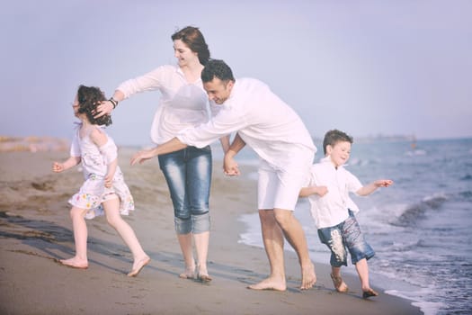 happy young family have fun and live healthy lifestyle on beach