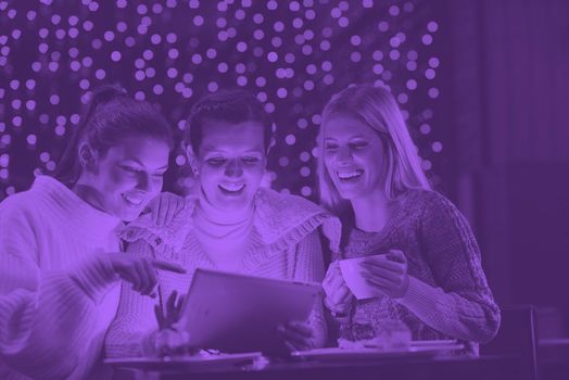 happy girls group  looking at a pc tablet in a home interior and have fun