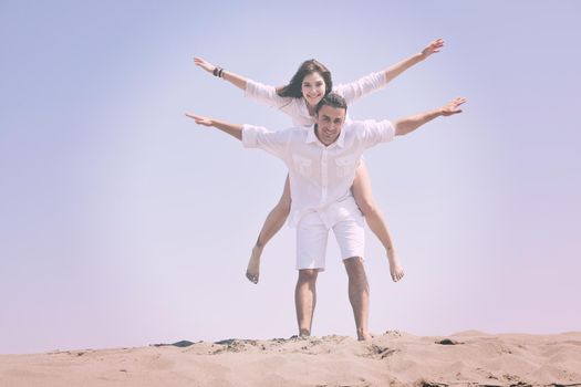 happy young couple have fun and romantic moments on beach at summer season and representing happynes and travel concept