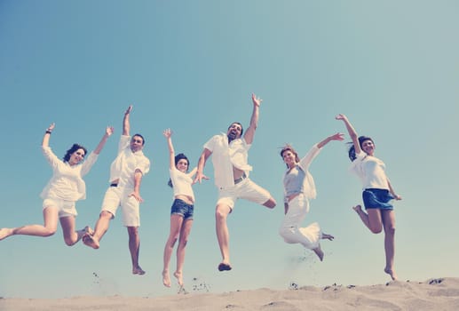 happy people group have fun  run and jump  on beach beautiful sand  beach