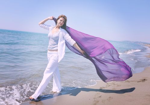 happy young woman relax on beautiful  beach at fresh summer morning and enjoy first ray of sun