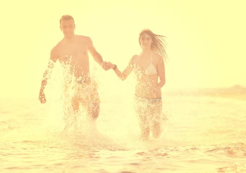 happy young couple have romantic time on beach at sunset