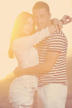 happy young couple have romantic time on beach at sunset