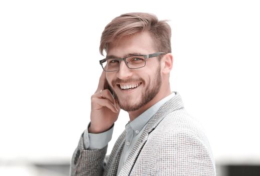 close up.smiling businessman talking on smartphone and looking at you