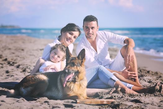 happy young family in white clothing have fun and play with beautiful dog at vacations on beautiful beach 