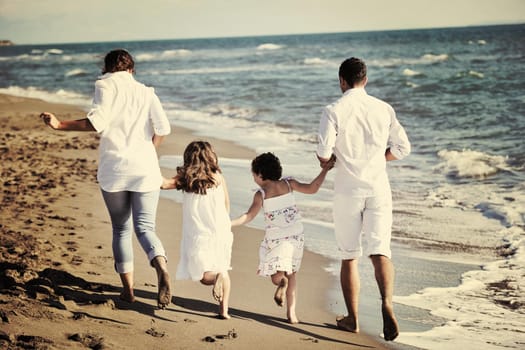 happy young family in white clothing have fun at vacations on beautiful beach 