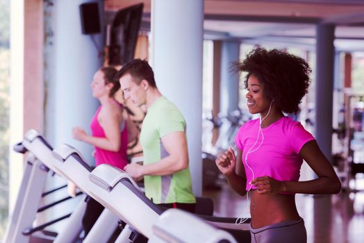 young people exercisinng a cardio on treadmill running chine in modern gym